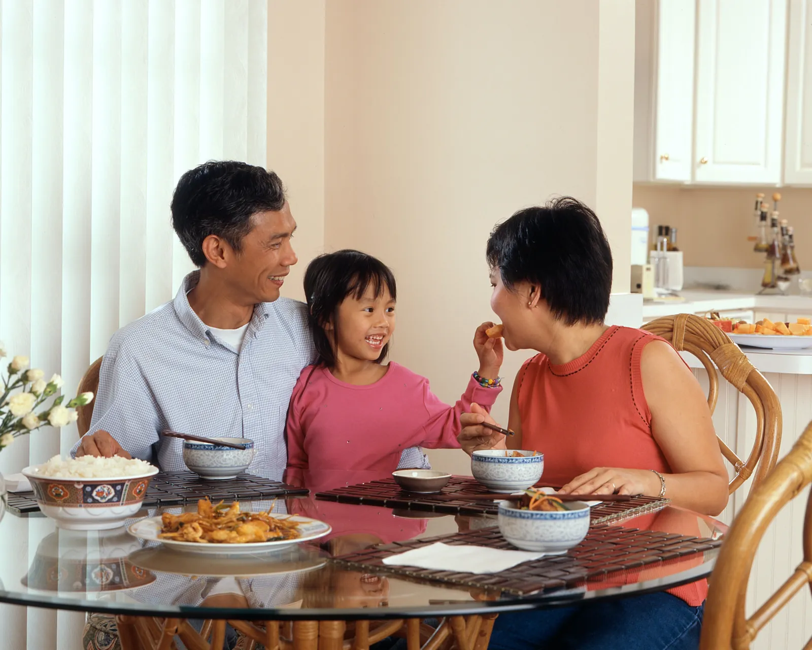 A family laughing together around the dinner table at home