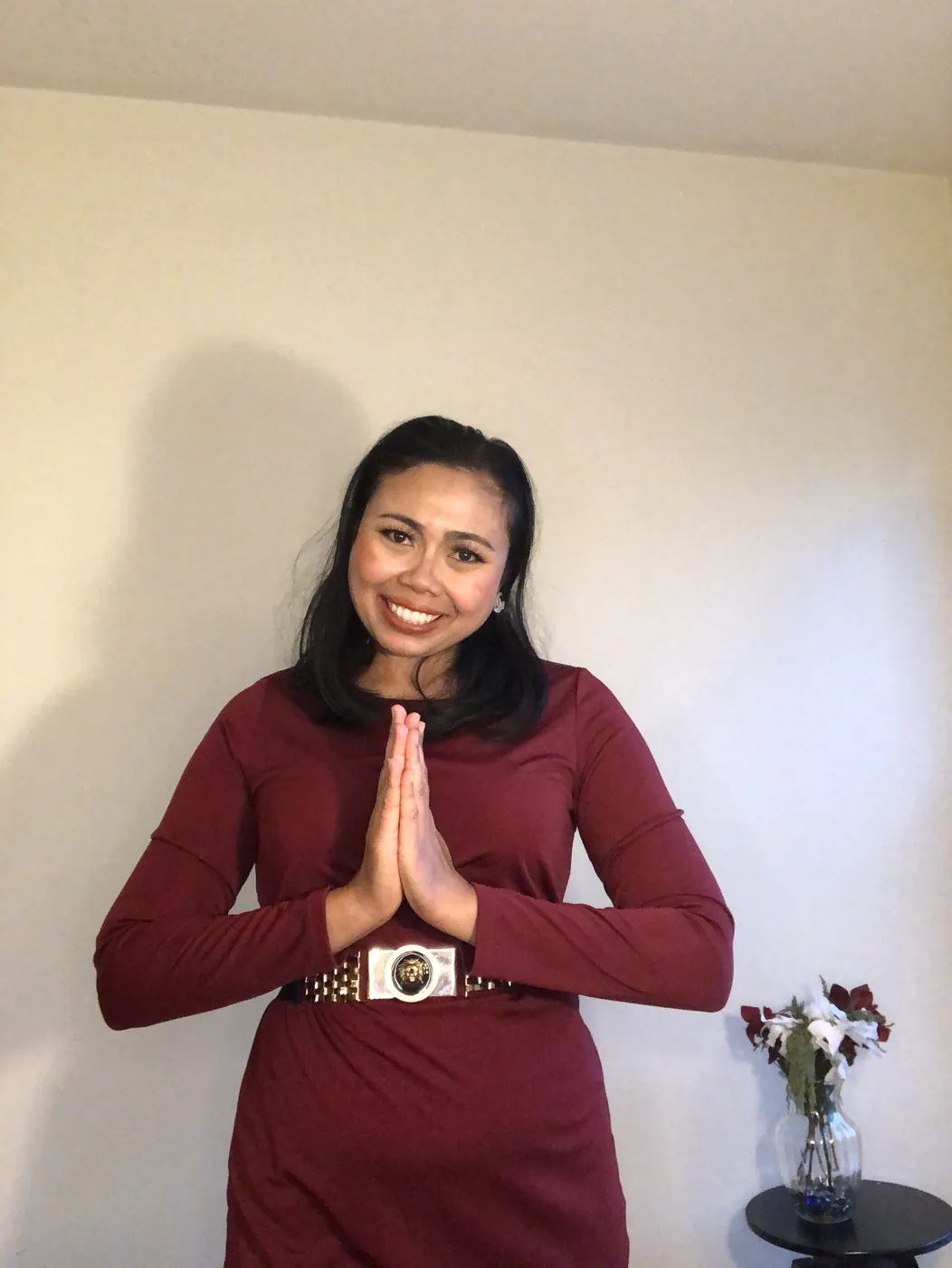 Krittaya smiling with her palms pressed together in a traditional Thai greeting