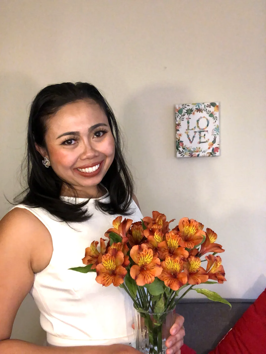 Krittaya smiling and holding a bouquet of orange lilies